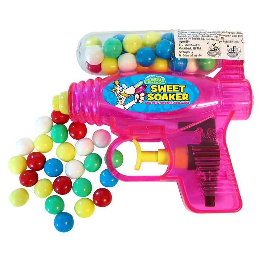 Pink toy water gun with colourful gum balls inside the water container. Toy displayed on a white background with some gum balls outside of the toy.