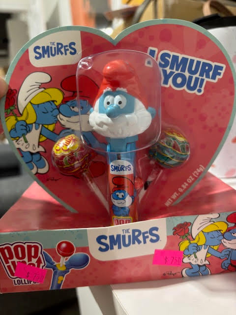 Smurfs-themed lollipop set with heart-shaped packaging in a store setting